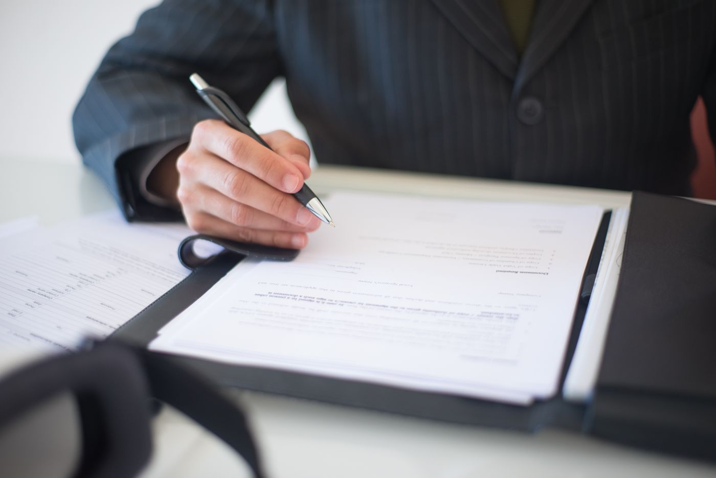 A professional signing documents at a desk